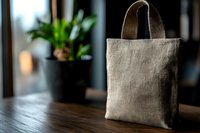 Natural linen tote bag on wooden table in modern interior with green plants, eco-friendly reusable shopping bag for sustainable lifestyle and zero waste living.