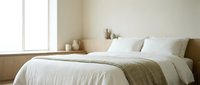 Cozy bedroom interior with neatly made bed featuring white linens and neutral bedding, minimalist decor, and natural light from window for home design projects.