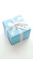 Elegant turquoise gift box with white lace ribbon and For You tag isolated on white background for special occasions and celebrations.