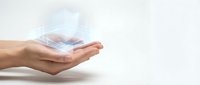Cupped hands holding glowing digital holographic house model with futuristic light effects on clean white background for real estate and property technology concepts.