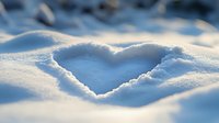 Heart shape drawn in fresh white snow with soft blue shadows, romantic winter scene captured in macro with shallow depth of field and natural lighting.