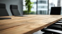 Modern wooden conference table with black office chairs in bright corporate meeting room, selective focus on natural wood grain surface texture.