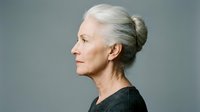 Elegant senior woman with gray hair in profile view against neutral background showcasing natural aging and mature beauty for lifestyle content.