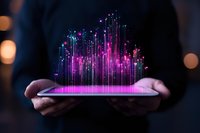 Glowing purple and blue digital light streams rise from tablet device held in hands against dark background, representing data visualization and technology advancement.