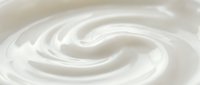 Smooth white cream swirl texture, close-up of fresh yogurt or sour cream with soft spiral pattern, creamy dairy product background.