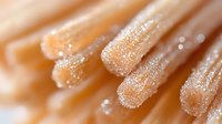 Sugar crystals on brown churros close up macro shot with selective focus and bokeh effect, sweet food photography for dessert menu and bakery advertising.
