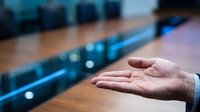 Young professional male hand extended in welcoming gesture above blue conveyor belt in industrial manufacturing facility, symbolizing logistics, supply chain management, and business operations.