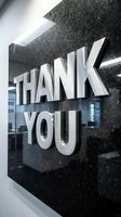 Thank you you message displayed on dark textured wall with metallic silver lettering and modern lighting, suitable for corporate gratitude campaigns, business signage, and appreciation marketing materials.