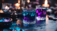 Vibrant blue and purple layered cocktail in crystal glass with ice cubes on dark background, illuminated by candlelight creating magical atmosphere for party drinks.