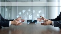 Business professionals discussing cybersecurity strategy with digital security icons floating between hands on conference table for corporate protection.