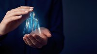 Businesswoman holding glowing digital building hologram in hands against dark background, representing real estate technology, smart city development, and innovative property investment solutions.