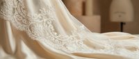 Ivory lace bridal gown detail with intricate embroidery and beadwork on luxurious fabric, suitable for wedding fashion, bridal collections, and formal wear design projects.