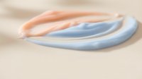 Smooth curved gel or silicone tubes in soft peach and light blue tones arranged on neutral beige surface, suitable for product mockups, cosmetic packaging, or medical device visualization.