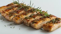 Grilled pork belly slices seasoned with fresh rosemary and herbs on light background, close up view of juicy meat with crispy golden crust.
