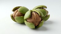 Opened green walnuts with brown nutmeat visible inside, isolated on white background for culinary, food styling, and recipe design projects.