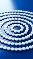 White round pills arranged in a spiral pattern on a vivid blue surface, symbolizing healthcare, pharmacy, and medicine concepts.