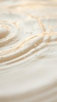 Soft ocean waves washing onto sandy beach with water droplets and foam in warm golden light creating peaceful coastal atmosphere for relaxation concepts.