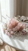 Rose quartz crystal cluster surrounded by delicate pink flowers on a marble table in soft natural light, evoking calm and wellness.