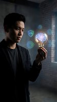 Asian businessman holding glowing lightbulb with digital brain and cybersecurity icons representing artificial intelligence innovation and technology solutions.