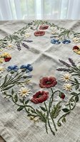 Vintage linen tablecloth with colorful hand embroidered wildflower motifs including poppies, daisies, cornflowers and lavender for rustic home decor and dining.