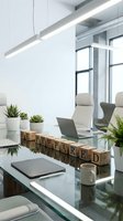 Modern office workspace with laptop, wooden letter blocks spelling "prepared," potted succulents, and minimalist desk setup under linear pendant lighting.