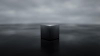 Black cube floating on calm water surface with overcast sky and minimalist composition for abstract design projects.