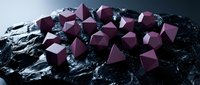 Geometric maroon cubes arranged on dark textured rock surface against moody sky, suitable for abstract backgrounds, design projects, and modern digital compositions.
