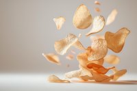 Crispy potato chips floating in air against light background, dynamic food levitation composition showing snack texture and crunchiness in warm tones.