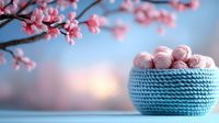 Pink macarons in blue knitted basket against blurred spring cherry blossom background with soft bokeh lights creating romantic pastel composition.