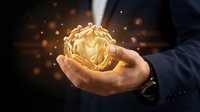 Male hand in dark business suit holding glowing golden sphere with light particles, representing innovation, success, and digital transformation for corporate and technology concepts.