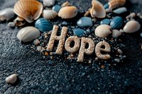 Word hope written in sand surrounded by seashells and blue pebbles on dark textured background, creating inspirational beach themed composition.
