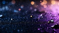 Magical glitter sparkles on dark background with purple and blue bokeh lights creating dreamy atmosphere. Abstract defocused particles for festive design.