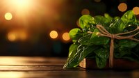 Green houseplant with twine bow on wooden surface against blurred warm bokeh lights background creates cozy home atmosphere in evening light.
