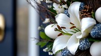 Pure white lily bloom with blue berries and white eggs in elegant floral arrangement, macro photography with soft selective focus and dark background.