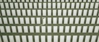 Green wooden lattice fence panel with rectangular openings creating geometric pattern for garden privacy and outdoor decoration projects.
