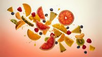 Fresh mixed fruit explosion with oranges, grapefruit, kiwi, berries and banana slices flying in air on gradient background for healthy eating concepts.