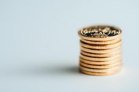 Stack of golden coins on light background showing financial stability and wealth. Close up macro photography with selective focus and copy space.