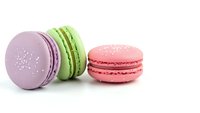 Colorful French macarons in pastel pink, green and purple flavors isolated on white background for bakery and dessert designs.