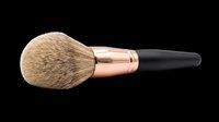 Fluffy powder makeup brush with rose gold ferrule and black handle, isolated on transparent background. Great for beauty clipart, stickers, t-shirt design, and print on demand.