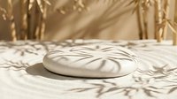 Zen stone with spiral pattern on sand garden with dried grass shadows, suitable for meditation, wellness, and spa design projects.