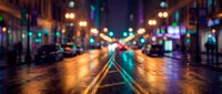 Blurred city street at night with colorful bokeh lights reflecting on wet asphalt creating atmospheric urban scene for backgrounds and design projects.
