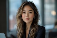 Professional Asian businesswoman with long wavy hair in modern office setting, confident corporate executive portrait for business marketing materials.