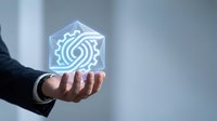 Businessman hand holding glowing holographic gear icon with digital technology symbol, representing innovation, automation, and smart business solutions for corporate applications.