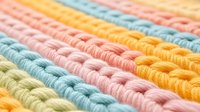 Colorful knitted texture with diagonal stripes in pastel pink, yellow, blue and beige colors. Close up macro shot of soft wool yarn creating cozy pattern.