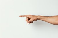 Male hand pointing finger to side against white background, showing direction or choice gesture, isolated arm demonstrating clear indication signal.