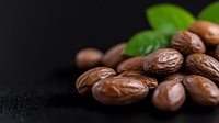 Fresh roasted coffee beans with green leaves on dark background, macro shot showing rich texture and natural aroma for cafe and restaurant marketing.