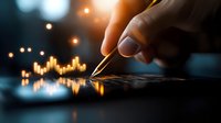 Male hand with pen analyzing glowing orange financial chart data on dark background, market statistics and trading analysis concept for business growth.