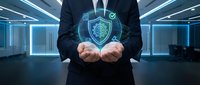 Businessman holding holographic cybersecurity shield with checkmark in modern office environment representing data protection and network security solutions.