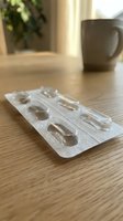 Empty medication blister pack on wooden table with coffee mug in background, healthcare and pharmaceutical concept for medical treatment adherence.