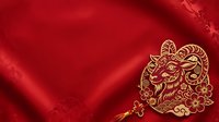 Young male goat with ornate golden horns and decorative patterns on red silk fabric background, suitable for lunar new year celebrations and festive design projects.
